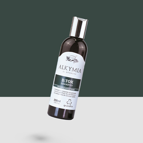 Imagem de um frasco de shampoo Alkymia D.Tox de 250 ml, flutuando sobre fundo verde e branco, destacando o produto da linha Grandha para desintoxicação capilar.